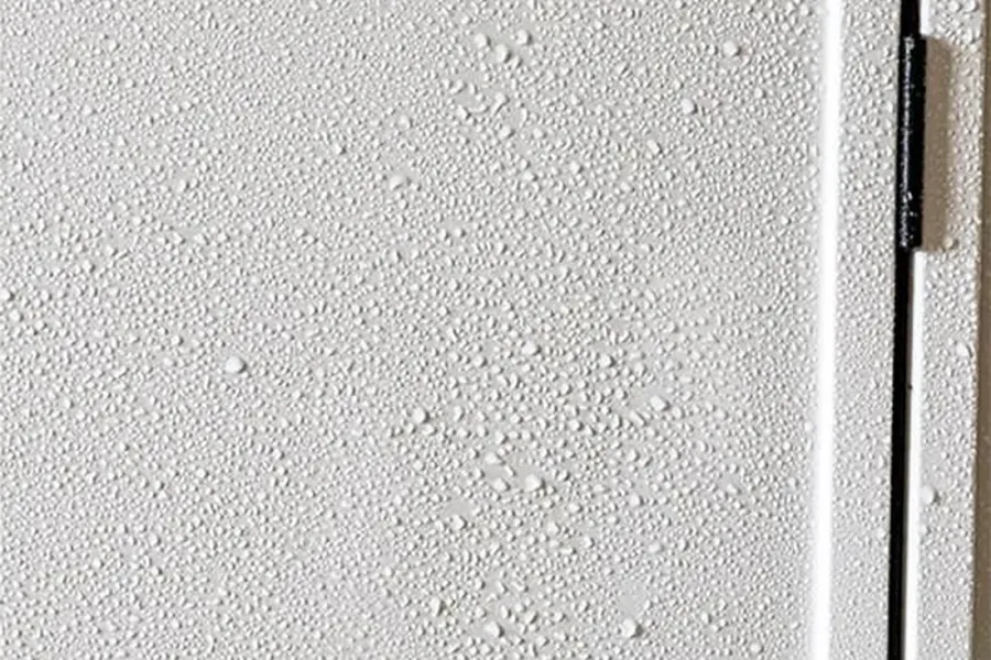 Wasser perlt auf der frisch versiegelten Außenwand eines Wohnwagens ab