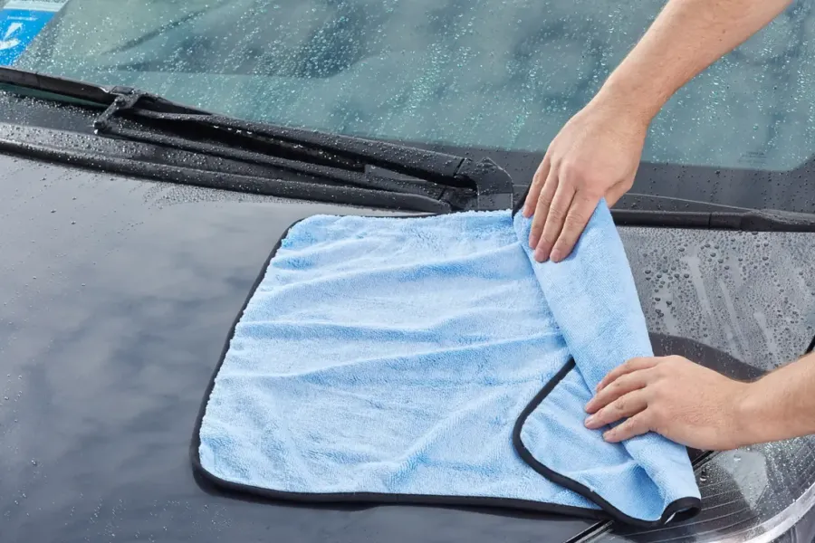 Motorhaube wird mit einem Mikrofaser-Trockentuch abgetrocknet