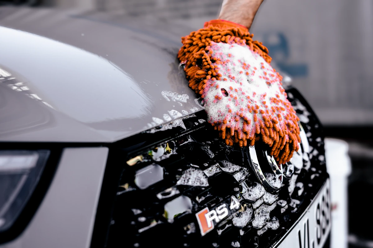 Auftragen von Snow Foam mit einer Schaumlanze auf ein Auto bei der Vorwäsche